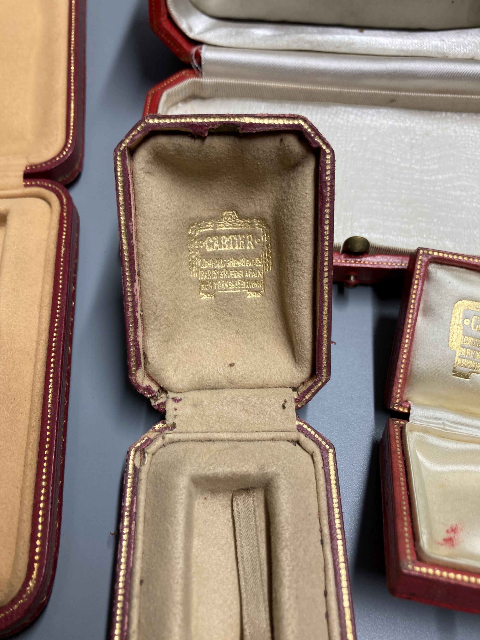 Five assorted Cartier gilt tooled leather jewellery boxes, largest 13.5cm.